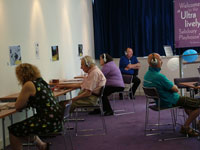 Listening to audio inside the Playhouse at the Living Voices Showcase